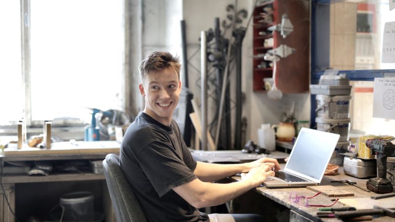 Bureau de créateur d'entreprise : ordinateur portable, calculatrice et formulaire d'immatriculation