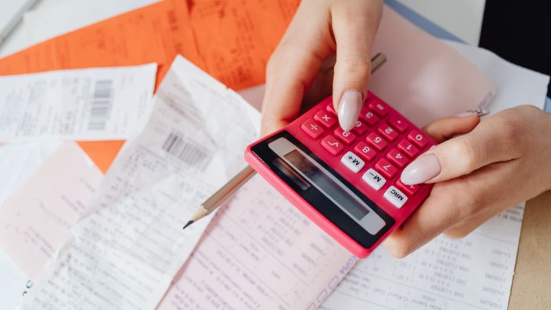 Calculatrice et relevé de chiffre d'affaires posés sur un bureau, calcul des cotisations en cours