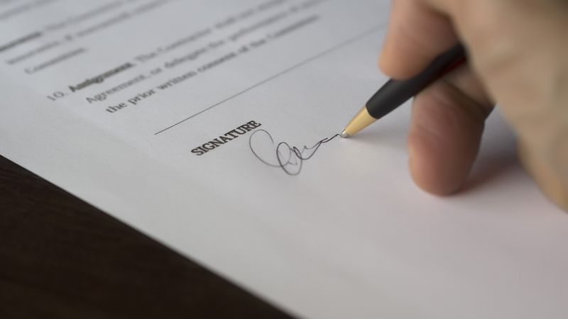 Créateur d'entreprise signant les statuts de sa SASU sur un bureau